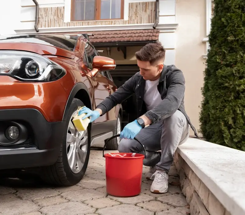 Lavage auto à domicile Auvers-Saint-Georges : professionnel intervenant sur un véhicule